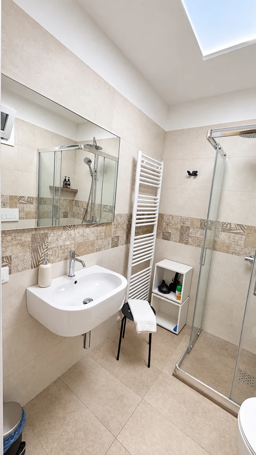 Lavabo sospeso con specchio e termoarredo nel bagno di Alkecè Red