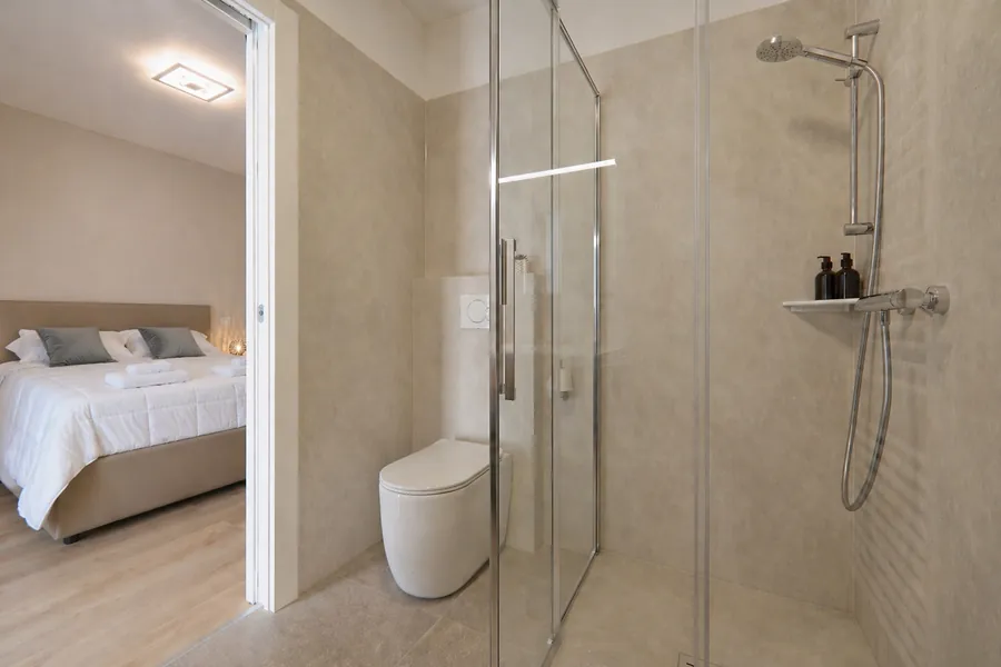 Doccia del bagno privato di Alkecè Silver con la camera matrimoniale sullo sfondo